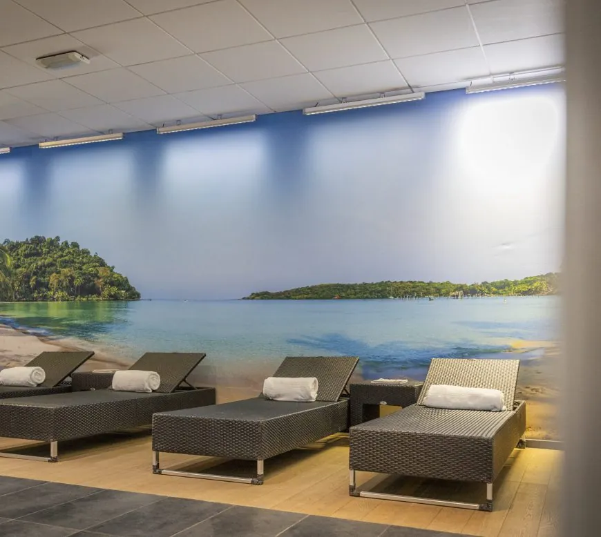 Ruheraum mit Liegen vor einem Strandbild im Parkhotel Horst